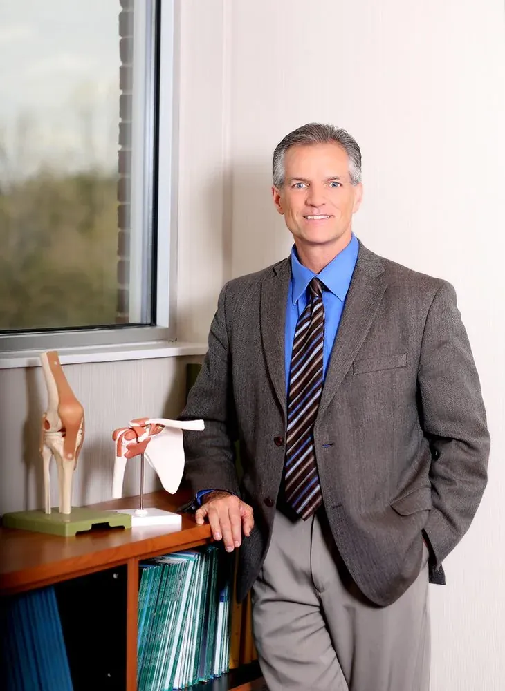 Dr. Thomas Perkins in his office beside knee and shoulder models