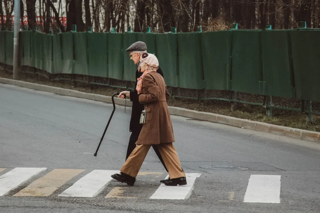 Elderly couple enjoying a stroll after deciding between walkers and canes from RHO. Proper use of crutches for safe walking and mobility support