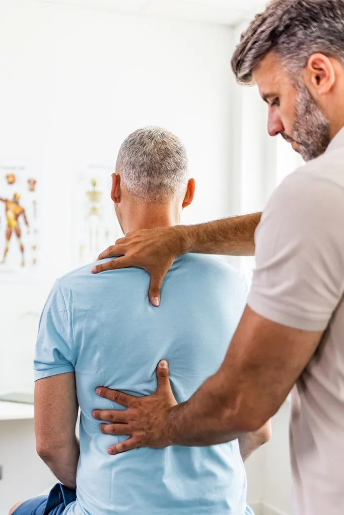 A patient holding a painful shoulder